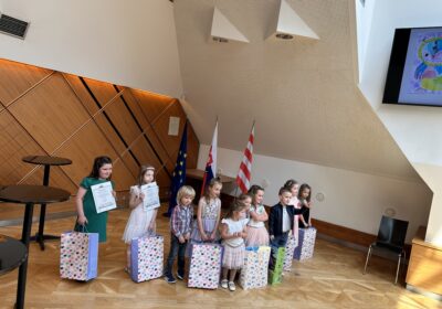 Na obrázku sú malé deti z materskej školy, ktoré v rukách držia diplomy a balíčky ako odmenu za sútaž