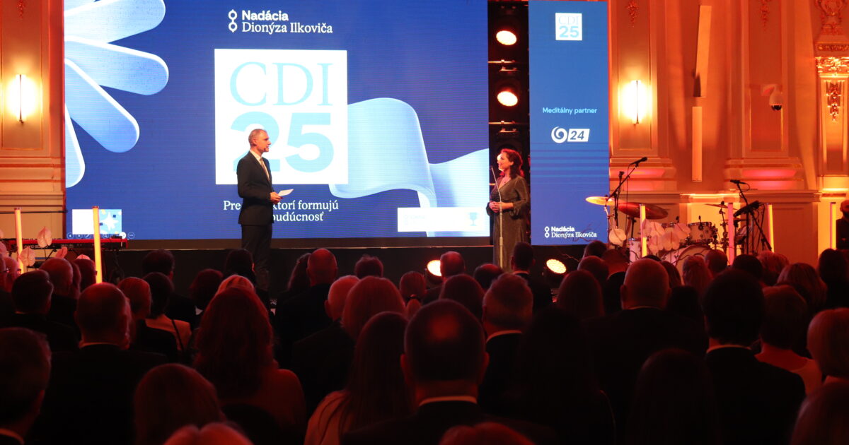 Na obrázku sa nachádza muž a žena na pódiu pri odovzdávaní cien