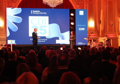 Na obrázku sa nachádza muž a žena na pódiu pri odovzdávaní cien