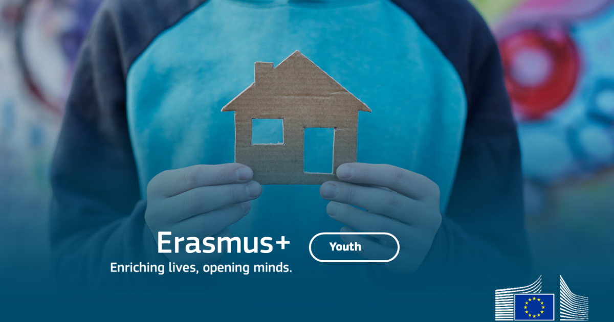 Mladý človek drží maketu domu z kartónového papiera