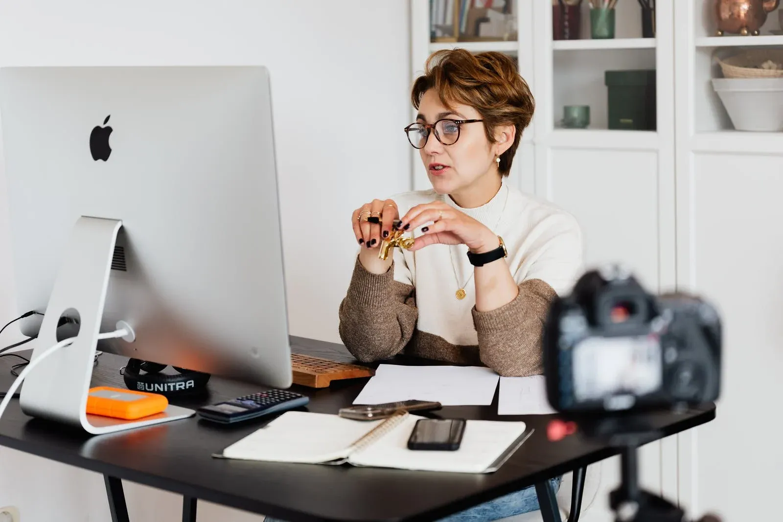 Na fotke žena za písacím stolom diskutuje cez online hovor.